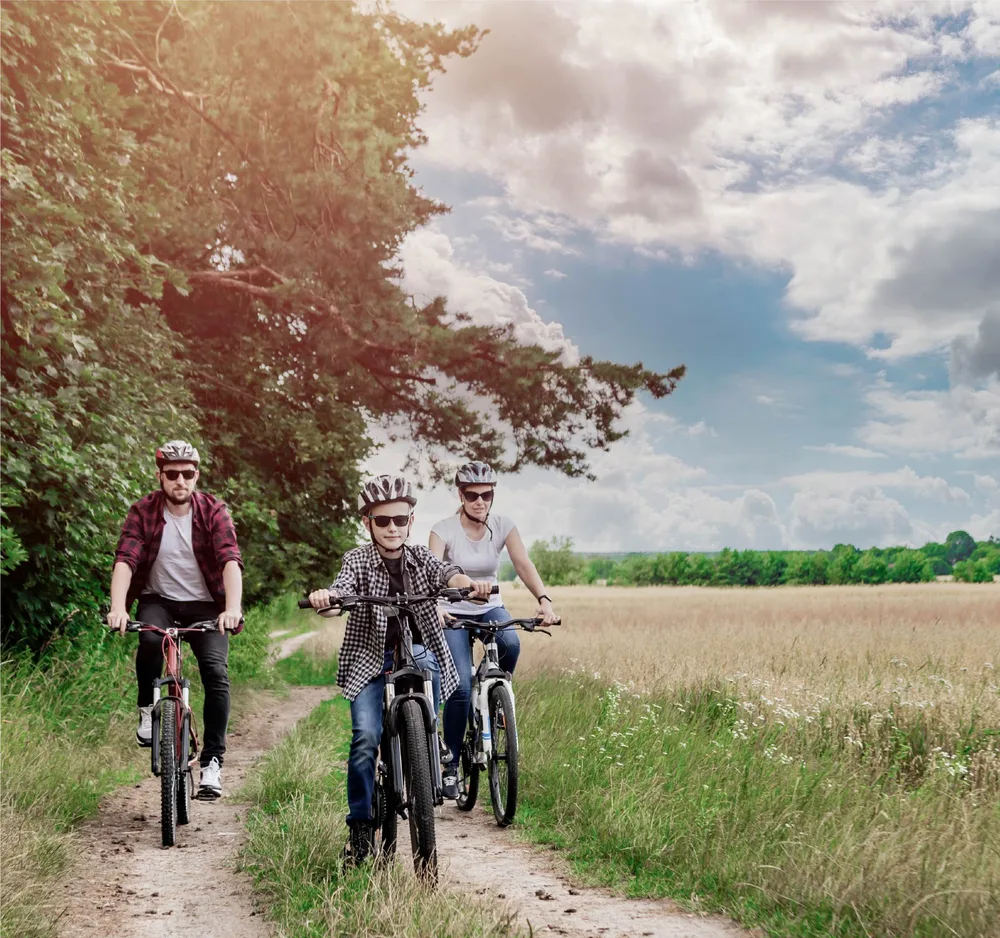 Family cycling along a green trail, from the Founder’s Walk lifestyle campaign